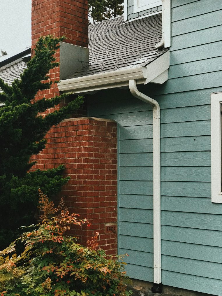 Clean white gutter and downspout on a shore home