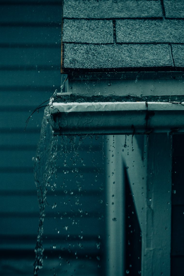 Rainwater overflowing a clogged gutter
